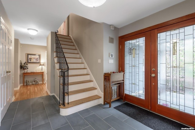 foyer entrance featuring french doors and dark tile patterned floors