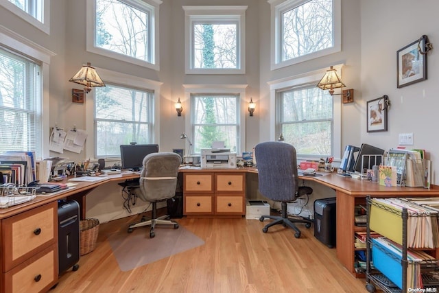 office area featuring light hardwood / wood-style flooring and a towering ceiling