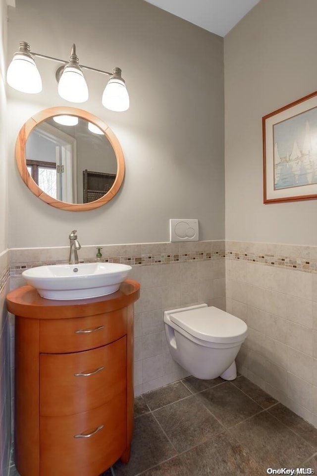 bathroom featuring tile patterned floors, vanity, and tile walls