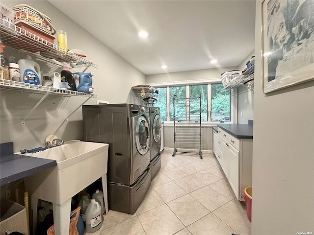 laundry room with light tile patterned flooring, cabinets, and washing machine and clothes dryer