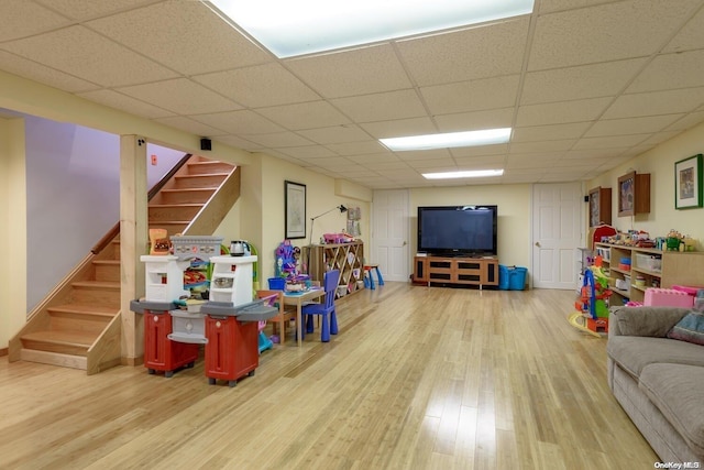 recreation room featuring hardwood / wood-style flooring and a drop ceiling