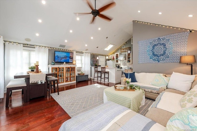 living room featuring dark hardwood / wood-style floors, vaulted ceiling, a wealth of natural light, and ceiling fan