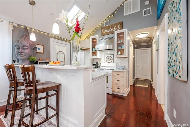 kitchen with dark hardwood / wood-style flooring, pendant lighting, white appliances, a center island with sink, and exhaust hood