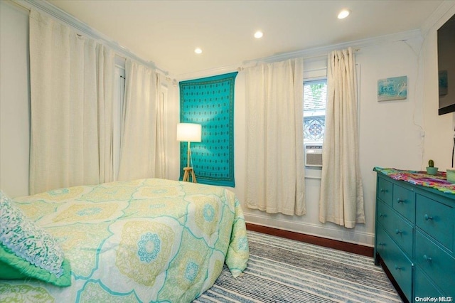 bedroom with dark hardwood / wood-style flooring and crown molding