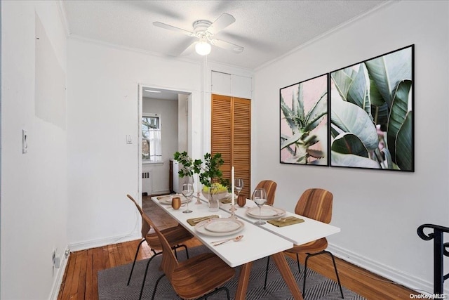 dining space featuring ceiling fan, radiator heating unit, hardwood / wood-style floors, a textured ceiling, and ornamental molding