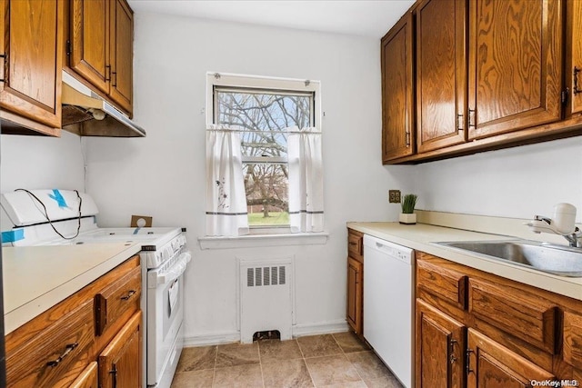 kitchen with radiator, sink, and white appliances