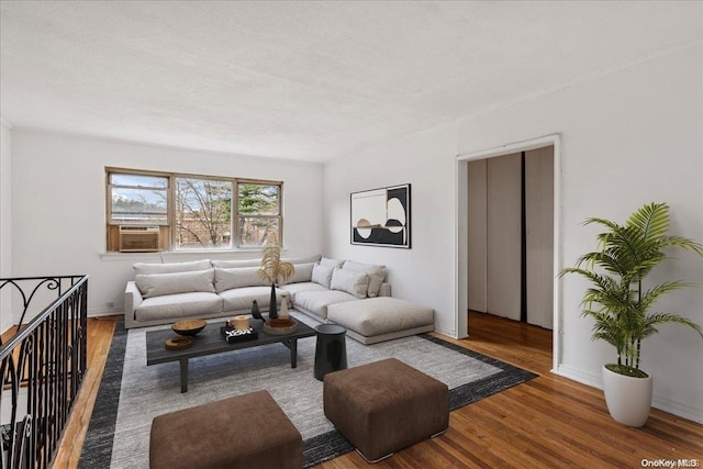 living room with hardwood / wood-style floors, cooling unit, and a textured ceiling