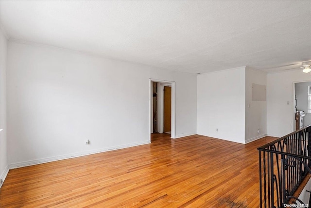 unfurnished room with a textured ceiling and light wood-type flooring