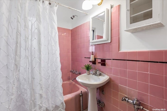 bathroom featuring shower / bath combo with shower curtain and tile walls