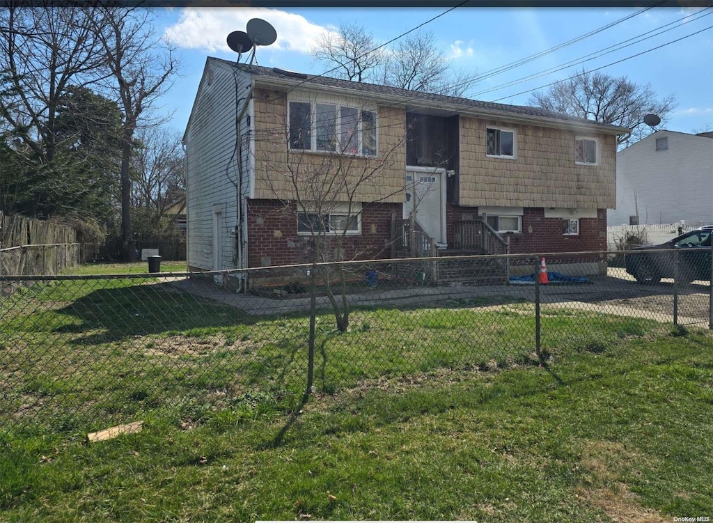 raised ranch featuring a front lawn