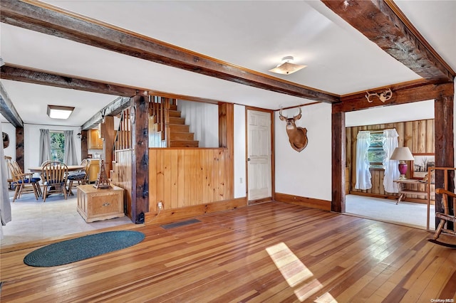 living room featuring beam ceiling and light hardwood / wood-style floors