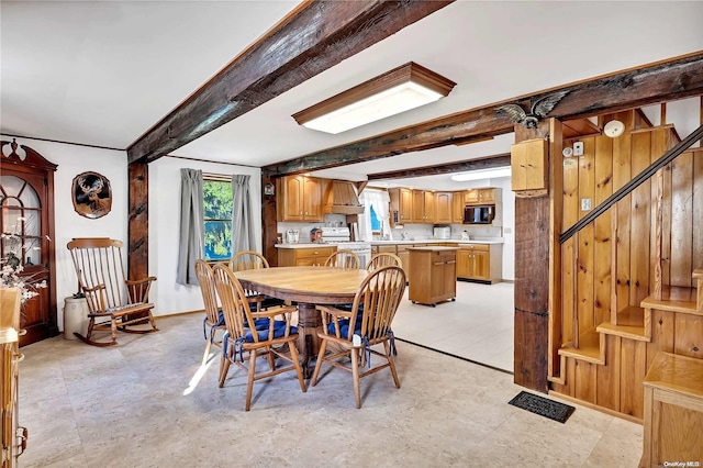 dining area with beam ceiling