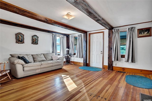 living room featuring beamed ceiling and light wood-type flooring