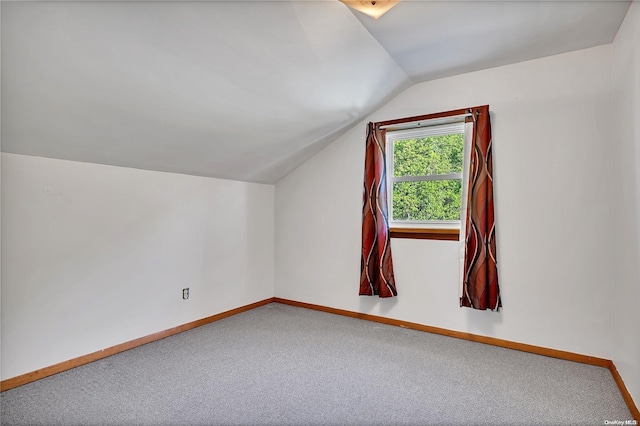 additional living space with carpet floors and vaulted ceiling