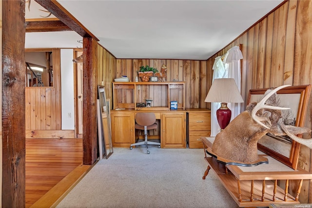 carpeted home office with wood walls