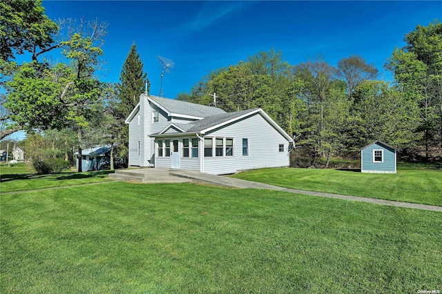 view of front of house featuring a patio area, a shed, and a front yard