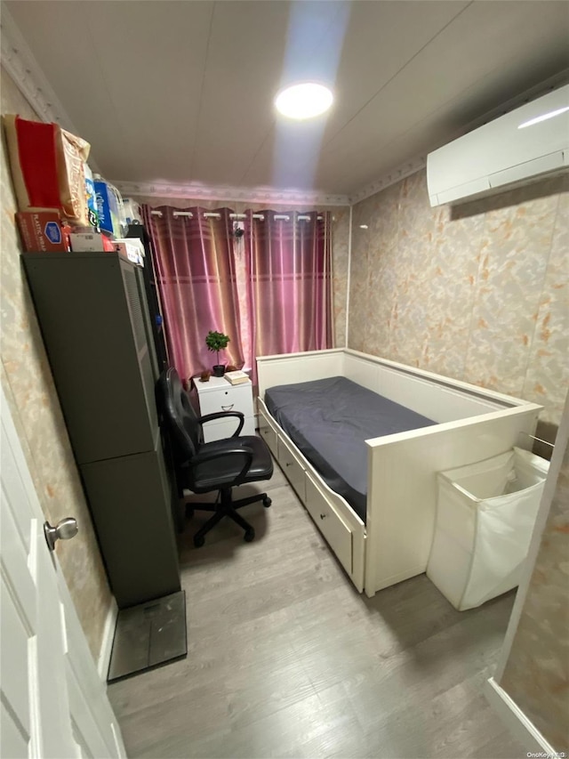 bedroom featuring light hardwood / wood-style floors and a wall mounted AC