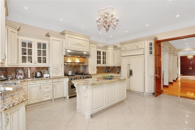 kitchen featuring extractor fan, cream cabinets, a kitchen island, and high end appliances