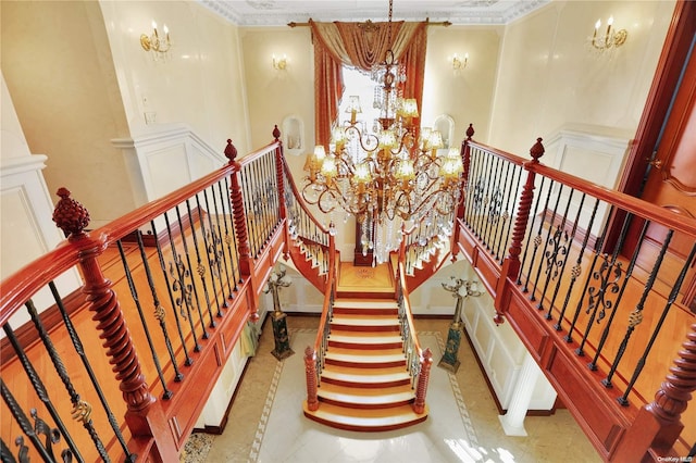 staircase with a notable chandelier and crown molding