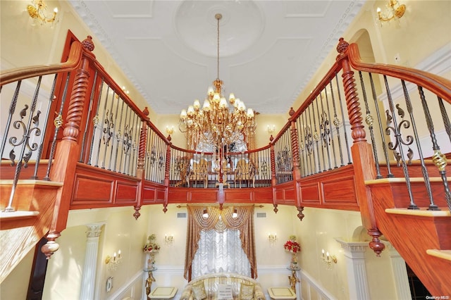 interior space with a high ceiling, an inviting chandelier, and crown molding