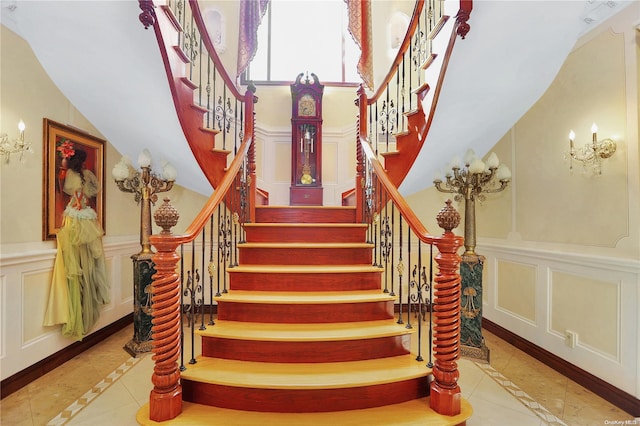 staircase featuring tile patterned floors and a high ceiling