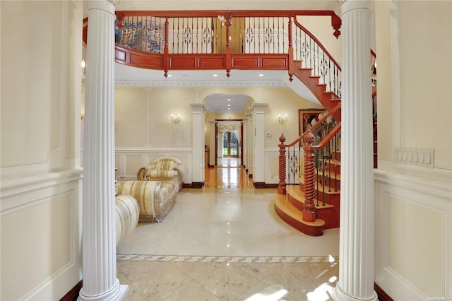 foyer entrance featuring light tile patterned flooring and decorative columns