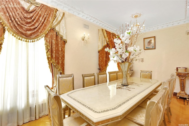 dining space featuring a notable chandelier, crown molding, and light hardwood / wood-style flooring