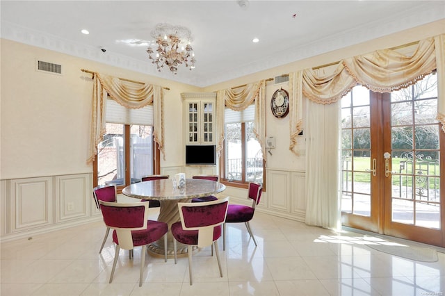 dining space with a healthy amount of sunlight, light tile patterned floors, and french doors