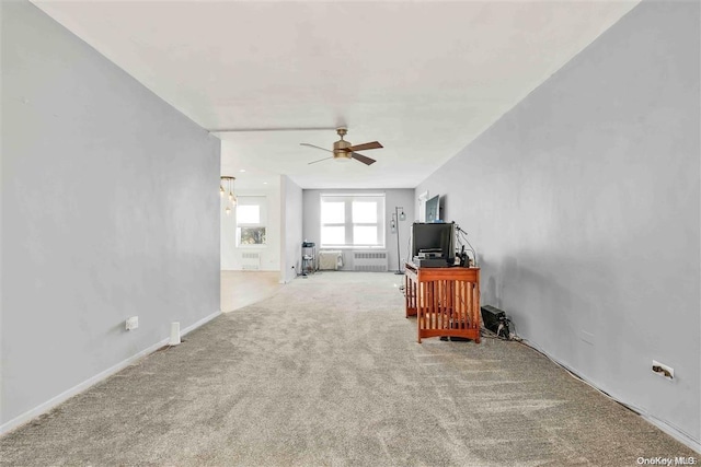 carpeted living room with radiator and ceiling fan