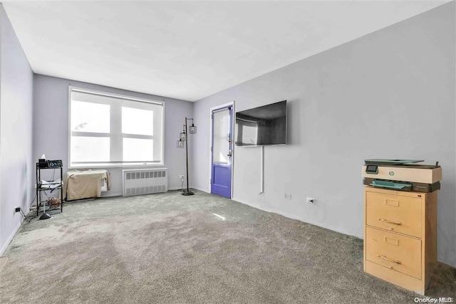 unfurnished living room featuring carpet flooring and radiator heating unit