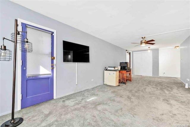 unfurnished living room featuring ceiling fan and carpet