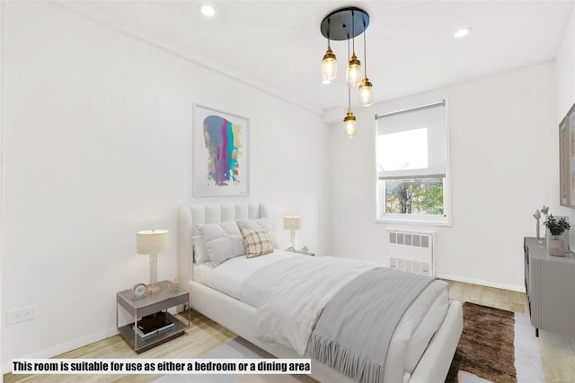 bedroom featuring radiator and light hardwood / wood-style flooring