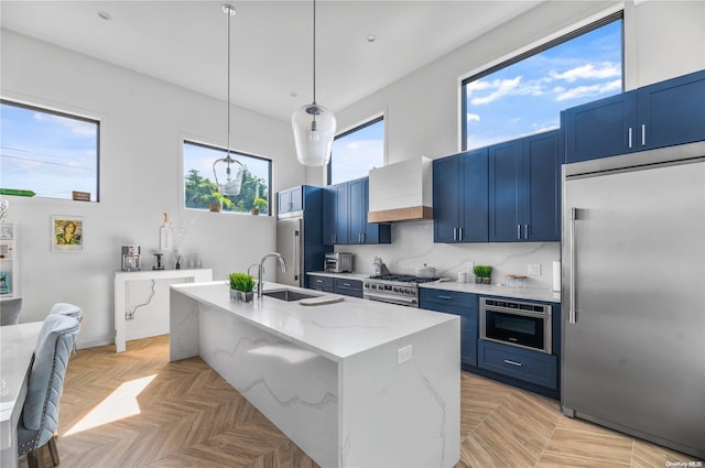 kitchen featuring a healthy amount of sunlight, high end appliances, light stone countertops, and sink