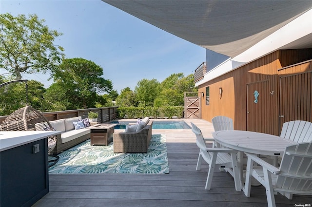 deck featuring an outdoor living space with a fire pit