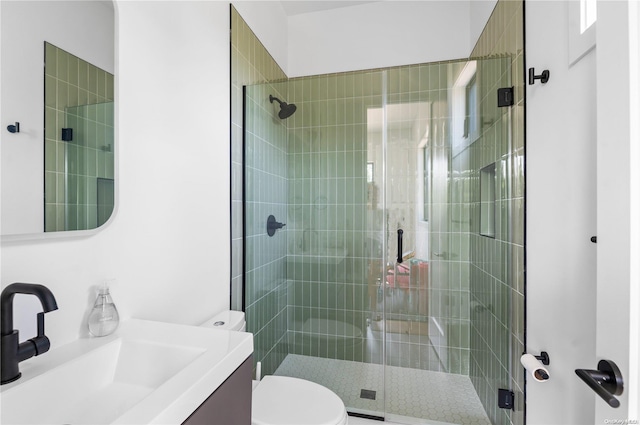 bathroom with an enclosed shower, vanity, and toilet