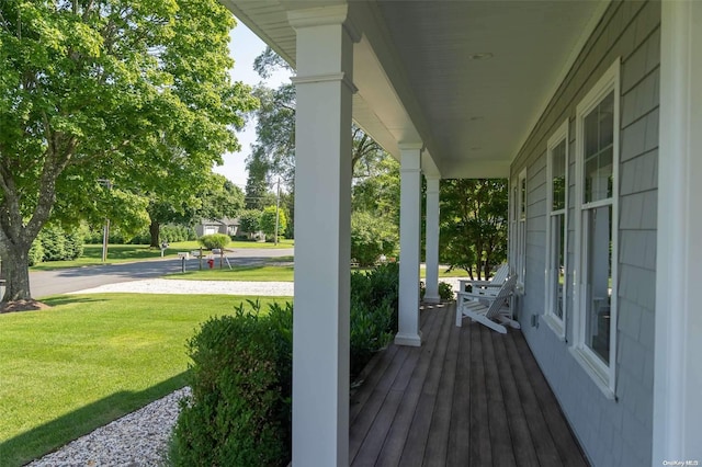 wooden deck featuring a lawn