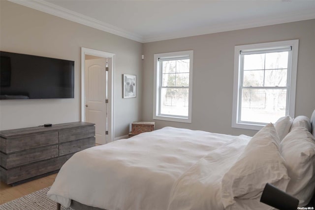 bedroom with ornamental molding and light wood-type flooring