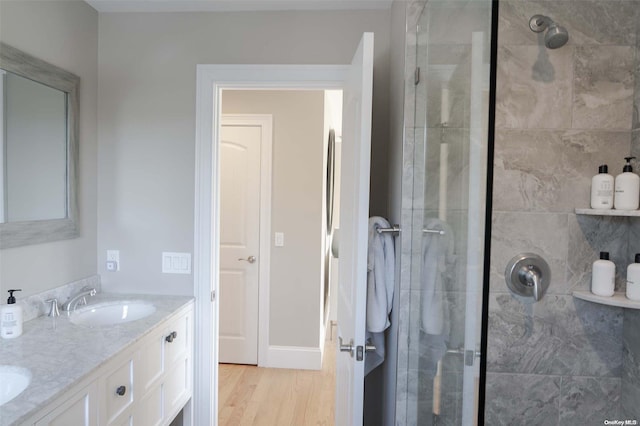 bathroom featuring hardwood / wood-style flooring, vanity, and an enclosed shower