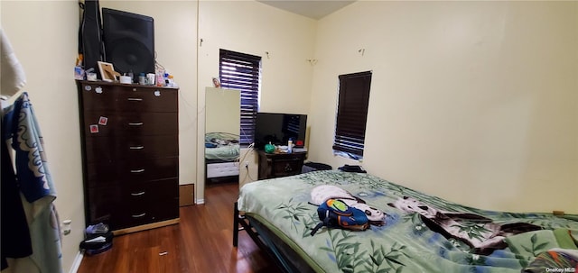 bedroom with dark hardwood / wood-style flooring