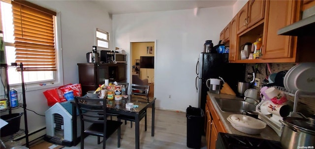 kitchen with tasteful backsplash, sink, and a baseboard heating unit