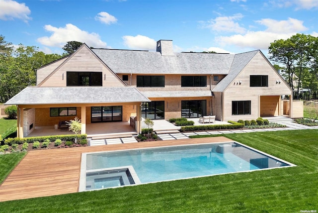 back of house with a yard, a patio area, and a swimming pool with hot tub