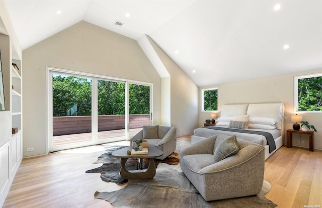 bedroom featuring light hardwood / wood-style floors, access to outside, and vaulted ceiling