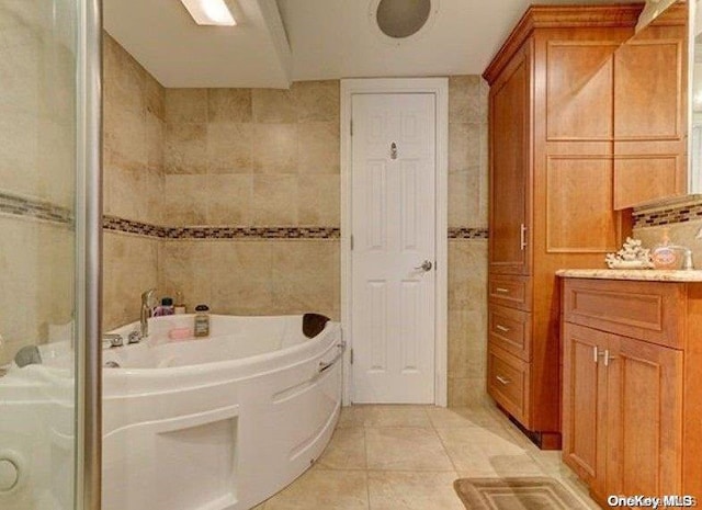 bathroom featuring tile patterned flooring, vanity, and tile walls