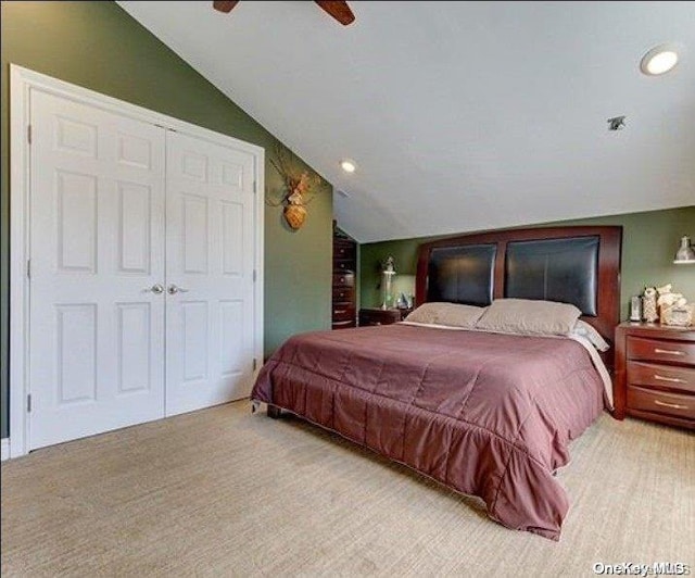 carpeted bedroom featuring a closet, ceiling fan, and lofted ceiling