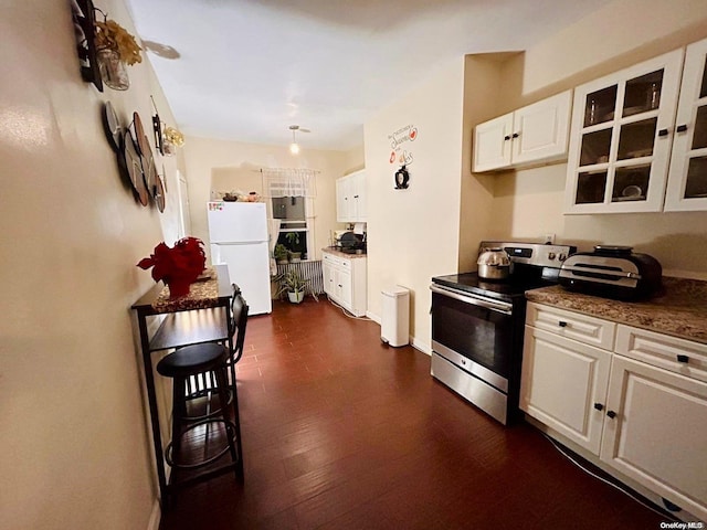 kitchen featuring dark hardwood / wood-style flooring, pendant lighting, white refrigerator, white cabinets, and stainless steel range with electric cooktop