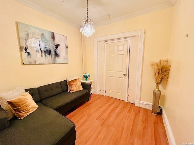 living room featuring hardwood / wood-style flooring, ornamental molding, and an inviting chandelier