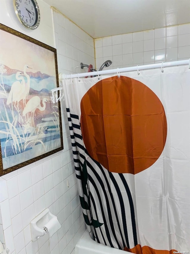 bathroom featuring tile walls and shower / tub combo with curtain