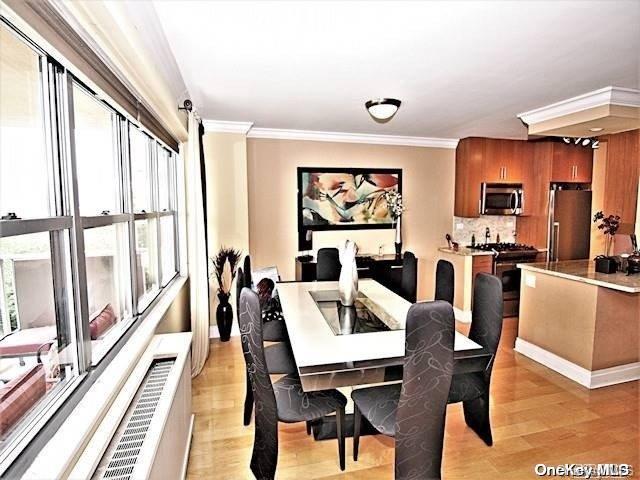 dining area with ornamental molding and light hardwood / wood-style flooring