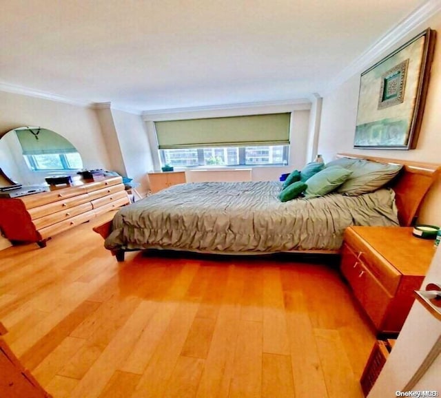 bedroom with hardwood / wood-style flooring and crown molding