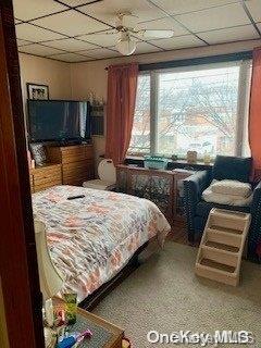 bedroom with multiple windows, a paneled ceiling, and ceiling fan